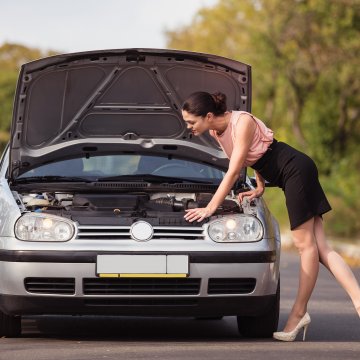 USAA MBI mechanical breakdown insurance woman checking car under the hood car on the road